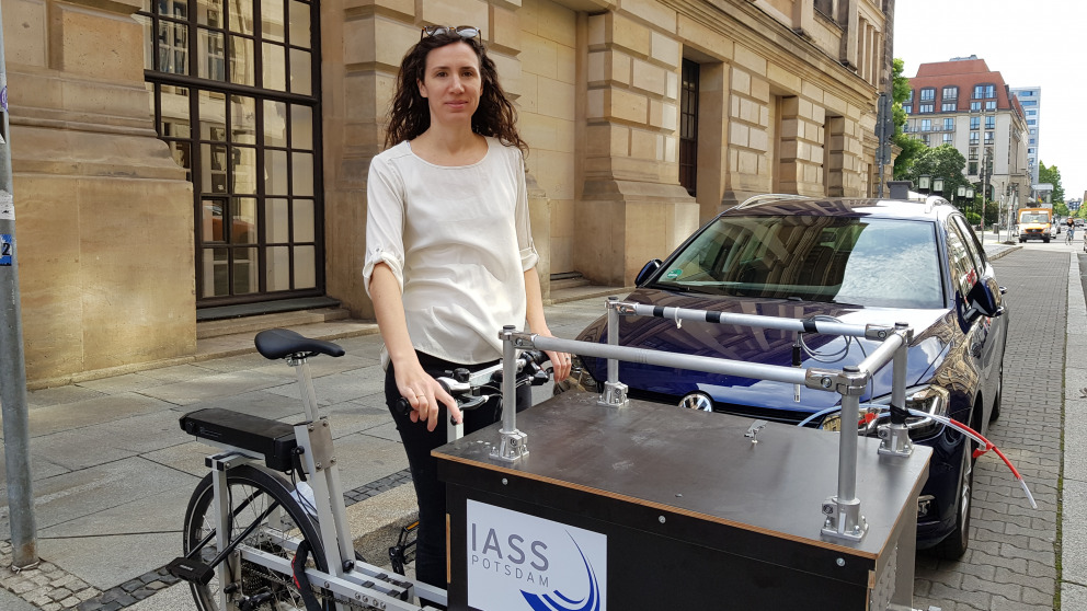 IASS researcher Erika von Schneidemesser with a bicycle for mobile air quality monitoring on Charlottenstrasse in Berlin. The cargo bike can be parked at different locations to measure air quality.